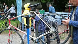 Ein Mechaniker überprüft ein Fahrrad und stellt sicher, dass es für die Radsaison startklar ist. (Bild: QM Dammwegsiedlung/ Weiße Siedlung)