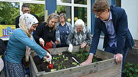 Gemeinsam bepflanzten die Anwesenden das Hochbeet vor dem Eltern-Kind-Zentrum. (Bild: QM High-Deck-Siedlung/Sonnenallee Süd W+P GmbH)