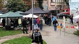 Menschen besuchen den Kleidertauschmarkt und Workshops beim Sasarcafé am Sasarsteig.