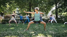 Menschen nehmen an einem Fitnesskurs im Freien im Rahmen des KiezFit-Projekts teil.