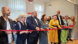 Gemeinsam eröffnen Vertreterinnen und Vertreter aus Verwaltung, wie Staatssekretär Stephan Machulik (Dritter von rechts), und des Pestalozzi-Fröbel-Haus das Nachbarschaftszentrum Bornhagenweg. (Bild: Katja Adelhof)   