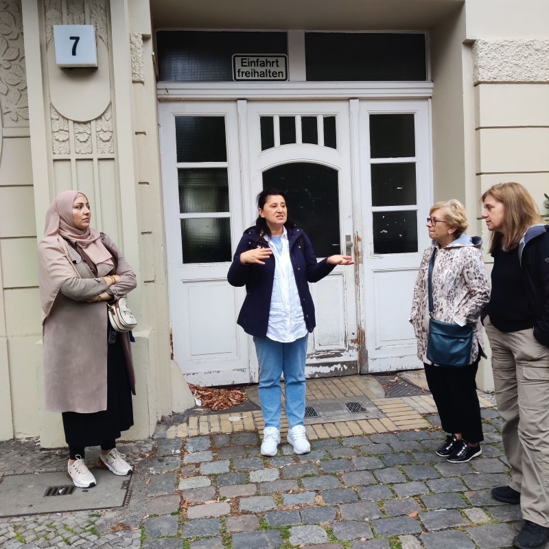 Gülaynur Uzun erzählt vor dem Haus, in dem ihre Mutter seit den 1970er Jahren lebt, Geschichten aus dem Alltag ihrer Familie. (Bild: Birgit Leiß)